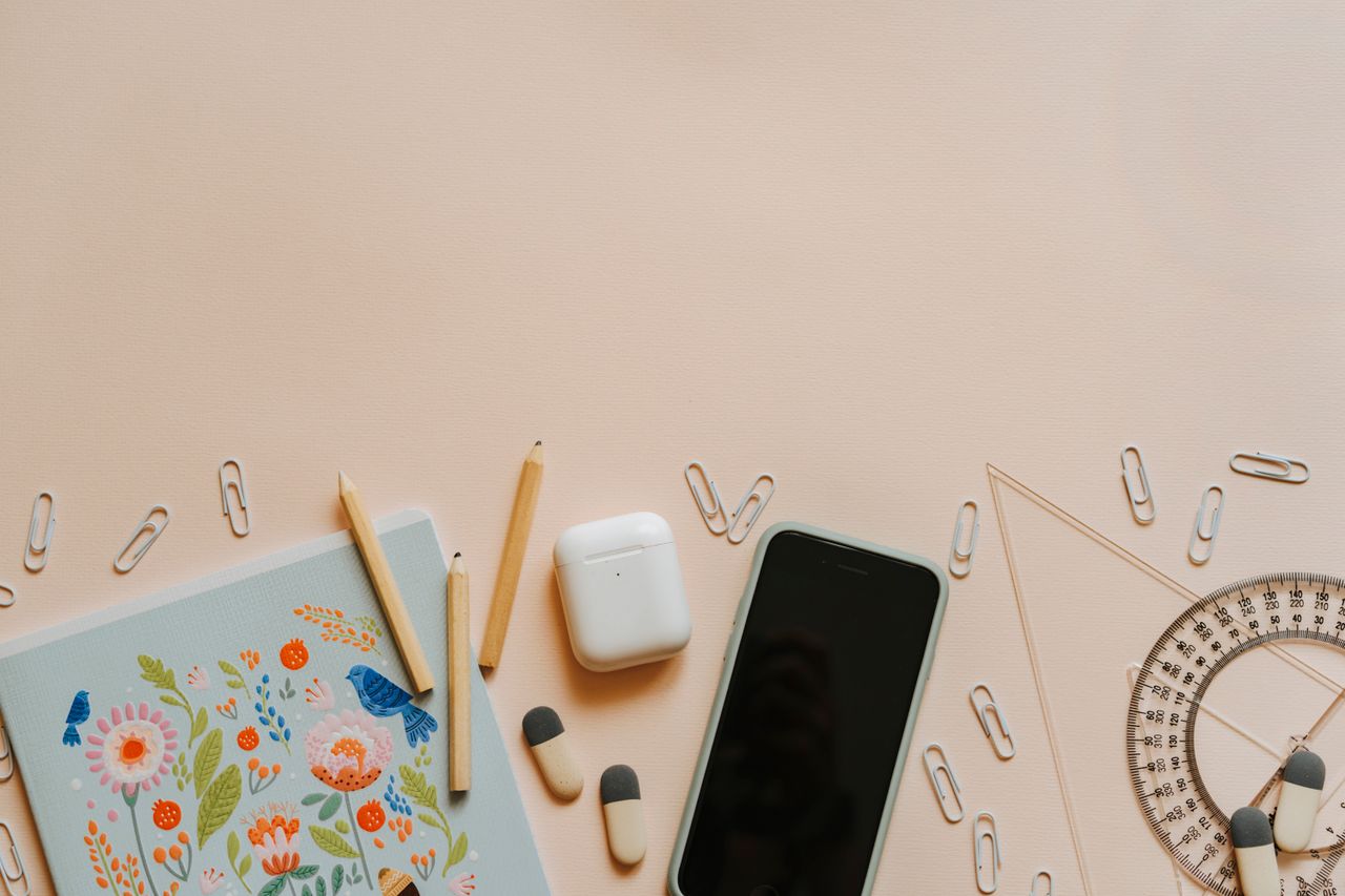 A top-down view of school supplies and tech gadgets on a desk, ideal for education themes.